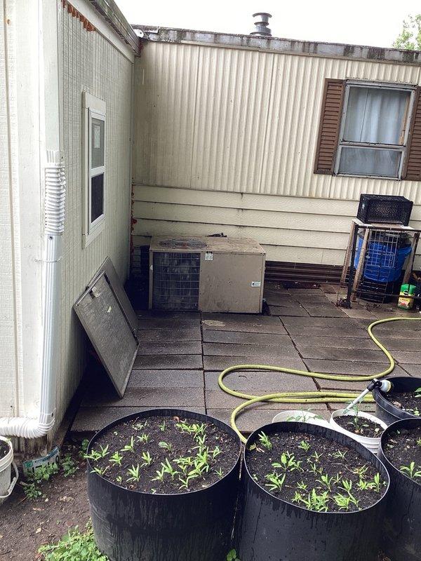 Responded to no cooling call at residential mobile home. Upon arrival, confirmed air conditioning system was running but discharging warm air instead of conditioned air. Diagnosed failed capacitor as root cause of cooling failure. Removed defective capacitor and installed new TITAN HD PRGD3535A replacement capacitor. Restored system to proper cooling operation and verified functionality before departure.