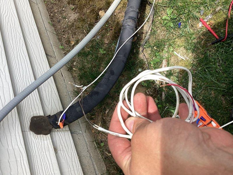 Responded to no cooling call and found thermostat common wire disconnected with low battery condition. Reconnected common wire to restore proper thermostat power, replaced damaged outdoor two-wire control cable, and verified system operation restored.