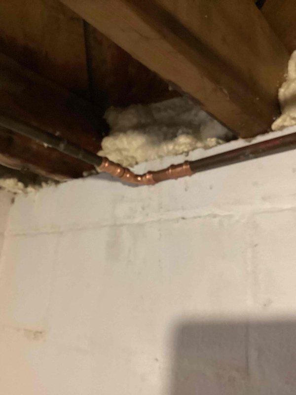 Responded to water leak in laundry room ceiling and located pinhole leak at 90-degree copper fitting on water supply line. Shut off main water supply to the home, then cut out the compromised section of copper pipe and fitting. Installed new copper pipe and 90-degree fitting using proper soldering techniques, restored water service to the home, and pressure tested the repair to confirm leak was fully resolved and system was operating correctly.