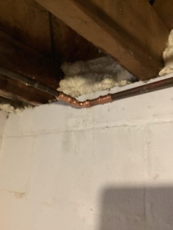 Responded to water leak in laundry room ceiling and located pinhole leak at 90-degree copper fitting on water supply line. Shut off main water supply to the home, then cut out the compromised section of copper pipe and fitting. Installed new copper pipe and 90-degree fitting using proper soldering techniques, restored water service to the home, and pressure tested the repair to confirm leak was fully resolved and system was operating correctly.