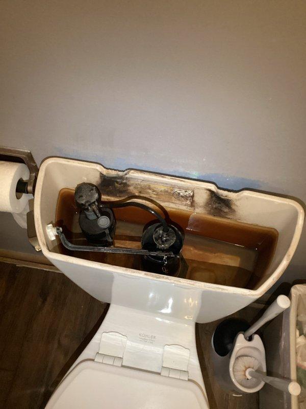 Responded to service call for toilet running continuously due to faulty flush handle mechanism. Upon arrival, confirmed handle was sticking and preventing proper valve closure. Removed tank lid, inspected internal components, and replaced defective flush handle assembly. Tested operation multiple times to ensure proper function and complete shutoff. Tank interior showed mineral deposits and staining but all mechanical components now operating correctly.