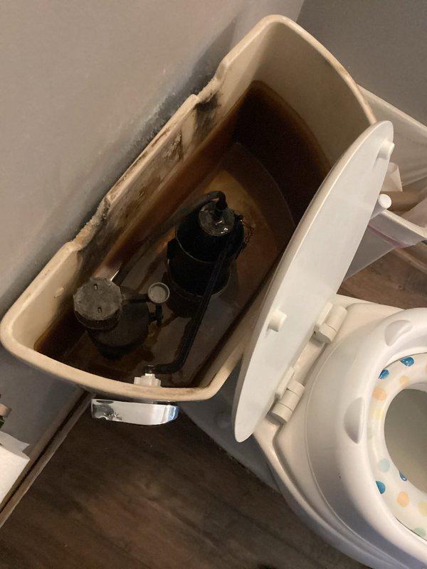 Responded to service call for toilet running continuously due to faulty flush handle mechanism. Upon arrival, confirmed handle was sticking and preventing proper valve closure. Removed tank lid, inspected internal components, and replaced defective flush handle assembly. Tested operation multiple times to ensure proper function and complete shutoff. Tank interior showed mineral deposits and staining but all mechanical components now operating correctly.