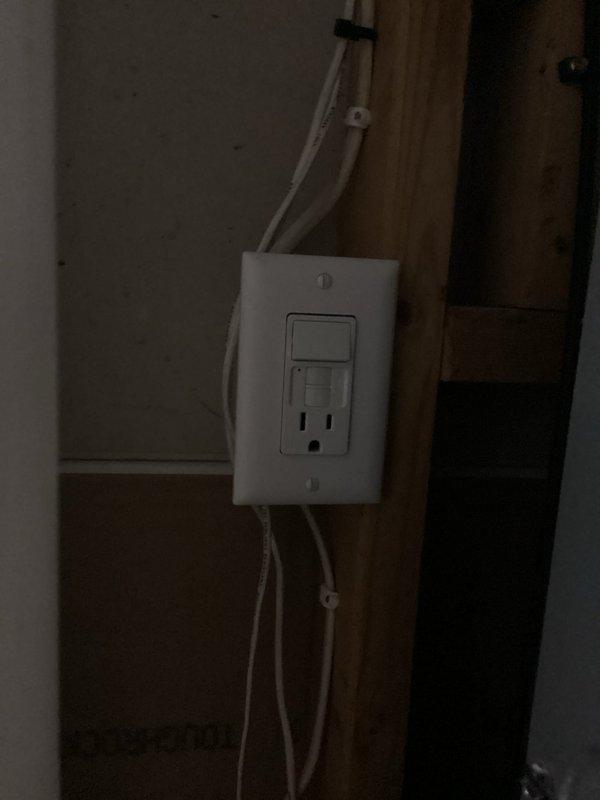 Responded to service call for faulty electrical outlet serving condensate pump in unfinished area. Upon arrival, identified defective outlet preventing pump operation and temporarily relocated pump power source to functioning receptacle to restore immediate functionality. Evaluated existing switch/GFCI combination installation and determined toggle switch was operating correctly. Provided estimate for GFCI outlet replacement, which was declined as switch functionality met requirements. Documented existing electrical configuration showing standard wall-mounted combination switch and GFCI receptacle with exposed framing in construction zone.