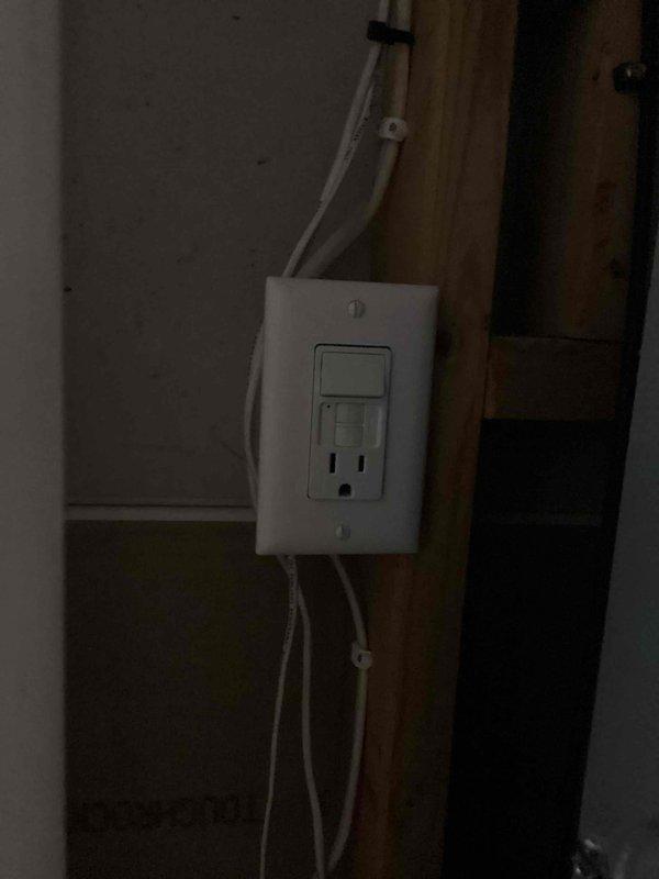 Responded to service call for faulty electrical outlet serving condensate pump in unfinished area. Upon arrival, identified defective outlet preventing pump operation and temporarily relocated pump power source to functioning receptacle to restore immediate functionality. Evaluated existing switch/GFCI combination installation and determined toggle switch was operating correctly. Provided estimate for GFCI outlet replacement, which was declined as switch functionality met requirements. Documented existing electrical configuration showing standard wall-mounted combination switch and GFCI receptacle with exposed framing in construction zone.