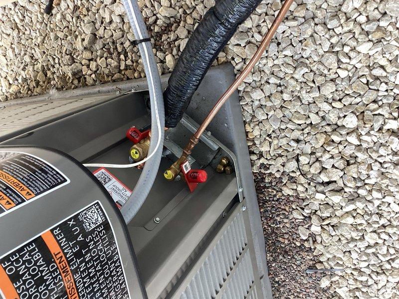 Responded to service call for refrigerant leak on outdoor condensing unit. Upon arrival, diagnosed leak at service valve connection on refrigerant line. Replaced defective service valve with new brass valve assembly, pressure tested system to verify repair integrity, and recharged unit to manufacturer specifications. Unit tested and operating normally upon departure.