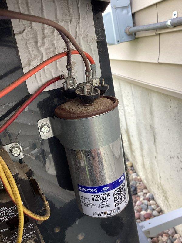 Responded to no cooling complaint on residential air conditioning system. Upon arrival, diagnosed failed dual-run capacitor preventing compressor and condenser fan operation. Removed defective Genteq capacitor and installed new replacement unit with proper voltage and microfarad ratings (40+5 MFD, 440/370 VAC). Verified system startup, confirmed proper compressor operation and cold air delivery. Unit restored to normal cooling operation.