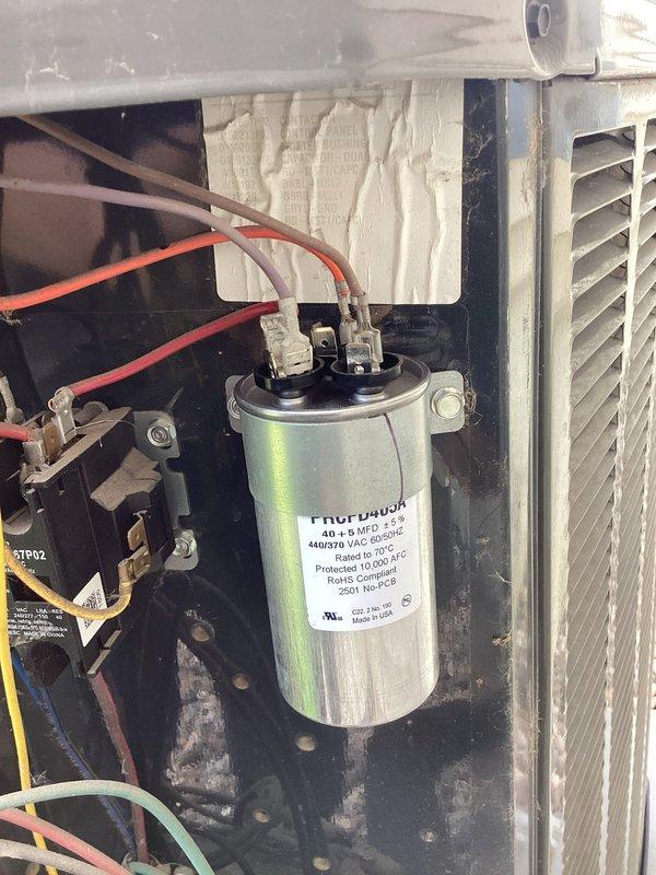Responded to no cooling complaint on residential air conditioning system. Upon arrival, diagnosed failed dual-run capacitor preventing compressor and condenser fan operation. Removed defective Genteq capacitor and installed new replacement unit with proper voltage and microfarad ratings (40+5 MFD, 440/370 VAC). Verified system startup, confirmed proper compressor operation and cold air delivery. Unit restored to normal cooling operation.