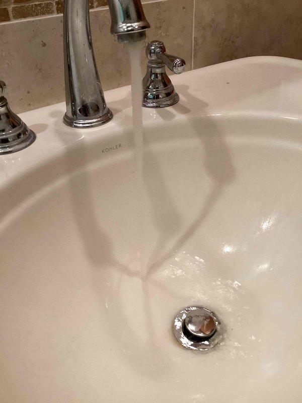 Responded to a backed-up lavatory faucet drain in a hallway bathroom with a pedestal sink configuration. Disassembled the trap assembly and ran a sink machine 25 feet into the drain line, successfully extracting a large wad of hair causing the blockage. Reassembled the drain assembly and tested the system by running the faucet for 3 minutes to confirm proper drainage with no further backup issues.