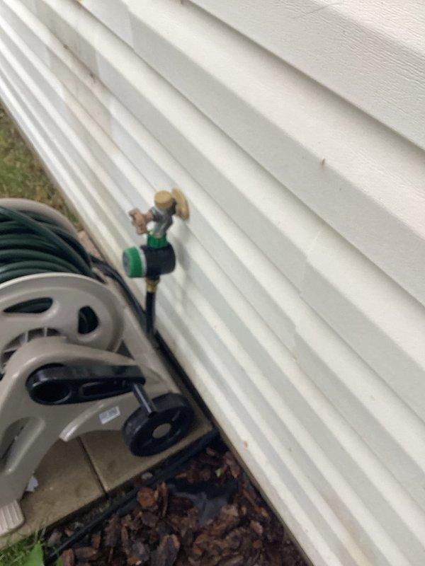 Responded to service call for outdoor hose bibb leaking during operation. Upon inspection, identified loose packing nut on backyard hose bibb assembly. Tightened packing nut to proper torque specification and tested faucet operation under full water pressure. Verified complete leak elimination and confirmed proper functionality of valve mechanism.