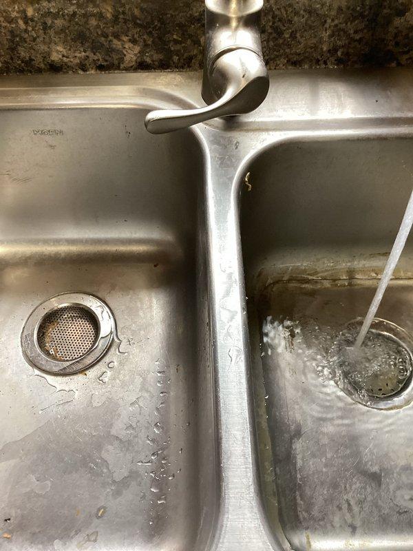 Responded to a clogged kitchen sink drain complaint. Upon arrival, confirmed the kitchen sink was not draining properly with water backing up in the basin. Deployed a sink machine and ran it approximately 25 feet into the drain line to attempt clearing the obstruction. Reassembled the drain assembly and tested the system by running the faucet, but the backup persisted. Due to the severity and location of the blockage beyond the scope of standard drain cleaning equipment, referred the customer to a specialized drain service provider for main line camera inspection and hydro-jetting services.