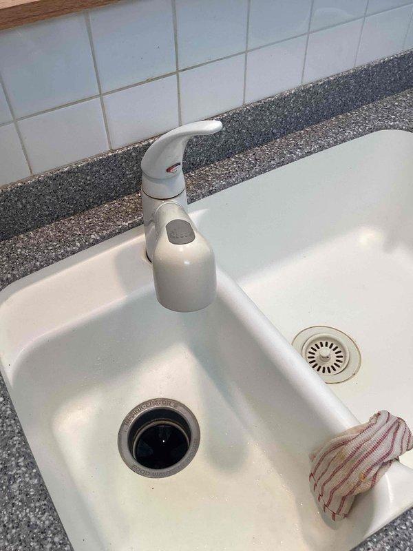 Arrived within scheduled window and successfully installed customer-provided single-handle kitchen faucet in white double-basin sink with speckled granite countertop. The installation included proper mounting, water supply line connections, and verification of operation with no leaks detected upon completion.