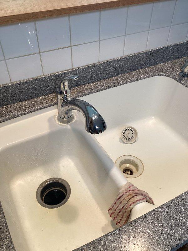 Arrived within scheduled window and successfully installed customer-provided single-handle kitchen faucet in white double-basin sink with speckled granite countertop. The installation included proper mounting, water supply line connections, and verification of operation with no leaks detected upon completion.