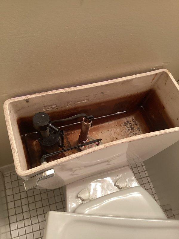 Responded to service call for toilets draining and flushing slowly. Upon arrival, conducted inspection of bathroom fixtures and identified aged toilet with deteriorated internal components. Removed tank lid and observed significant rust-colored staining, mineral deposits, and corrosion throughout tank interior, affecting flush valve assembly and fill valve mechanism. Determined that internal component degradation and age of fixture were causing poor flush performance and slow drainage. Recommended and performed complete toilet replacement due to extent of deterioration and inefficiency of existing unit. Removed old toilet, prepared flange and floor surface, and installed new toilet with updated flushing mechanism to restore proper operation and drainage performance.
