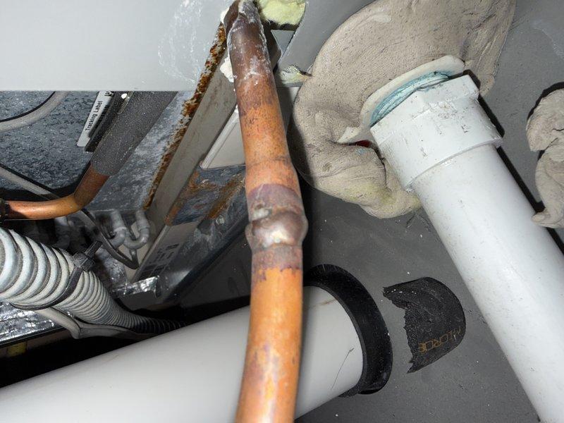 Responded to service call for refrigerant leak search on HVAC system. Located active leak at liquid line connection point where it meets the evaporator coil, evidenced by corrosion and oxidation on copper piping. Successfully pumped down the system, repaired the leak at the liquid line connection, and documented the corroded components with photographs for service records.
