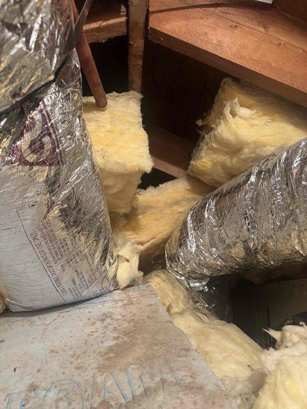 Responded to no cooling complaint and found no power at air handler. Accessed attic space and moved ductwork to diagnose system. Traced electrical issue to breaker panel where a disconnected wire was discovered with no available breaker positions. Documented findings with photos showing the disconnected wiring at the electrical panel and attic access area. Advised customer that an electrician would need to properly reconnect the wire and address breaker panel capacity before air conditioning system could be restored to operation.