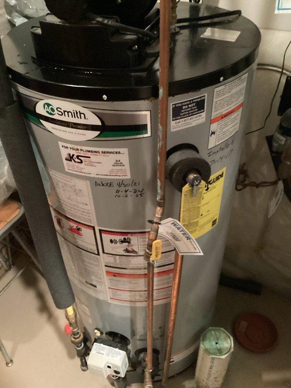 Completed installation of A.O. Smith tanked water heater with proper copper piping connections, shut-off valves, and water sensor at base of unit. Provided estimates for both water heater and water softener replacement, with photographic documentation of completed installation showing all safety labels, connection points, and proper placement in utility room.
