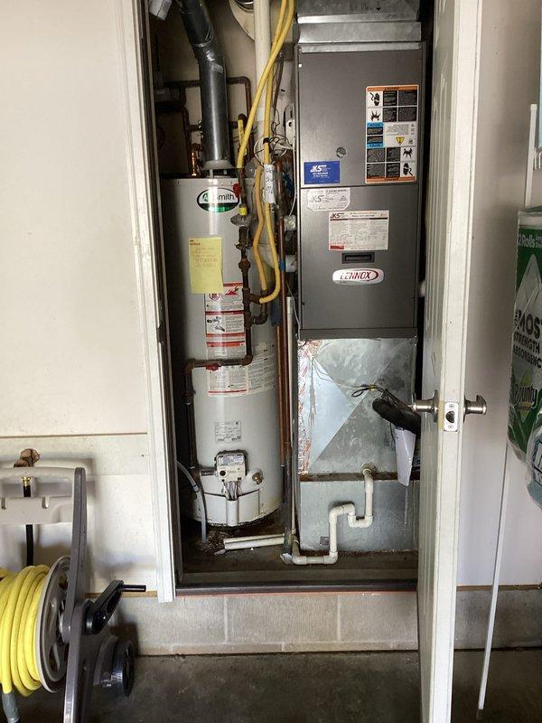 Completed installation of Impression Series two-piece water softener system in utility closet. Mounted wall control unit with digital display above storage tank, connected all necessary plumbing lines, and verified proper system operation alongside existing water heater and HVAC equipment.