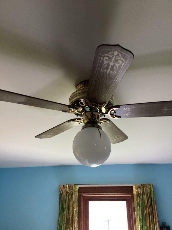 Responded to service call for non-functioning ceiling fan with operational light fixture. Upon inspection, diagnosed faulty pull-chain mechanism preventing fan motor operation while light remained unaffected. Presented repair options to customer and sold complete ceiling fan replacement. Removed existing decorative ceiling fan with brass-finished housing, five ornamental blades, and frosted globe light fixture. Installed new ceiling fan unit, ensuring proper electrical connections, secure mounting, and verified full functionality of both fan motor and lighting components upon completion.