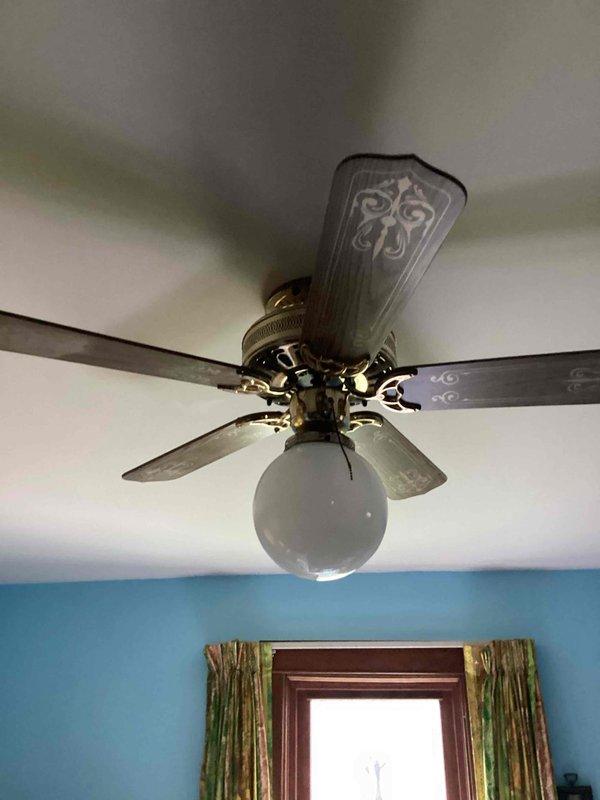 Responded to service call for non-functioning ceiling fan with operational light fixture. Upon inspection, diagnosed faulty pull-chain mechanism preventing fan motor operation while light remained unaffected. Presented repair options to customer and sold complete ceiling fan replacement. Removed existing decorative ceiling fan with brass-finished housing, five ornamental blades, and frosted globe light fixture. Installed new ceiling fan unit, ensuring proper electrical connections, secure mounting, and verified full functionality of both fan motor and lighting components upon completion.