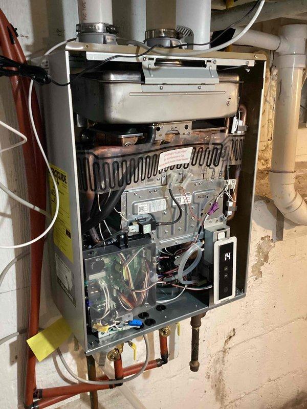 Responded to service call for Richmond tankless water heater displaying error code 14 and failing to operate properly. Upon inspection, found heat exchanger overheating during ignition attempts. Diagnosed issue as mineral buildup requiring descaling maintenance. Contacted manufacturer technical support to confirm error code 14 indicates need for heat exchanger descaling procedure. Explained findings and recommended descaling service to resolve overheating condition and restore proper operation. Customer elected to purchase descaling kit and perform maintenance independently. Documented unit condition with photos showing internal components and manufacturer identification.