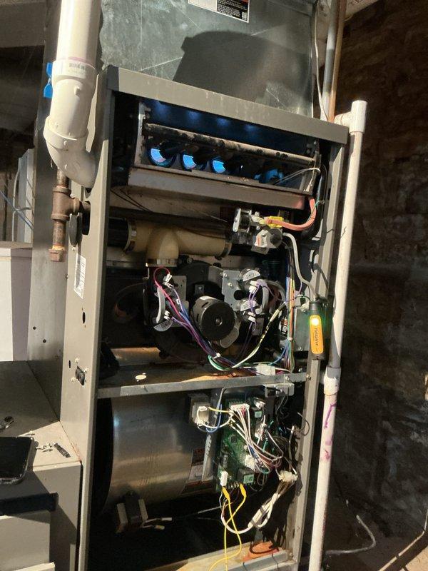 Performed routine furnace tune-up and discovered burners with significant rust and oxidation preventing proper ignition. Documented equipment condition with photographs showing corroded burner assemblies and discolored circular openings. Provided estimate for burner replacement, which was approved for future repair.