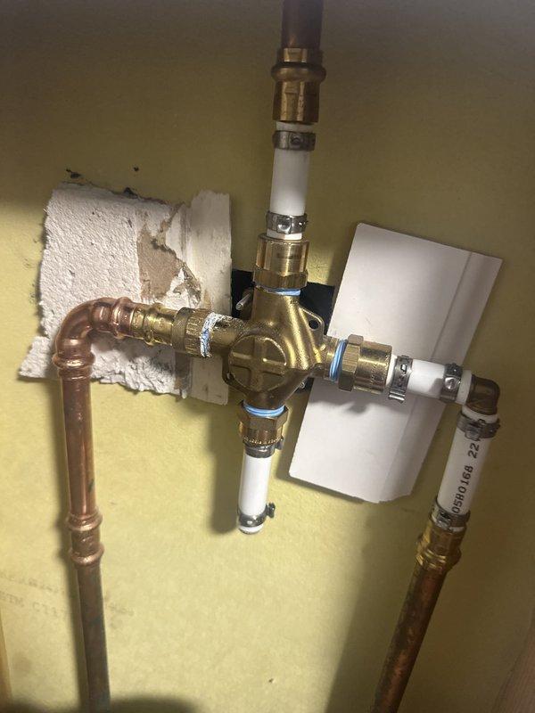 Responded to callback for water line leak that had been previously addressed by restoration company. Upon arrival, located active leak at brass mixing valve manifold junction. Inspected copper supply lines and PEX distribution piping connected to central brass fitting with compression fittings. Repaired failed connection point where leak originated, replaced compromised compression rings and ferrules at valve assembly. Secured all pipe connections at manifold, tested system under pressure to verify repair integrity. No further leaks detected upon completion of pressure test.