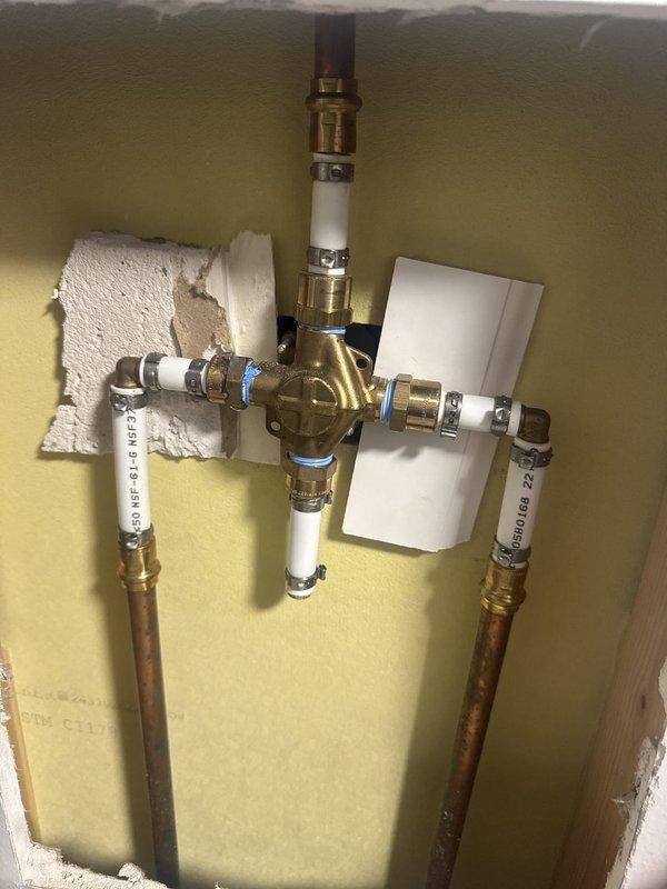 Responded to callback for water line leak that had been previously addressed by restoration company. Upon arrival, located active leak at brass mixing valve manifold junction. Inspected copper supply lines and PEX distribution piping connected to central brass fitting with compression fittings. Repaired failed connection point where leak originated, replaced compromised compression rings and ferrules at valve assembly. Secured all pipe connections at manifold, tested system under pressure to verify repair integrity. No further leaks detected upon completion of pressure test.