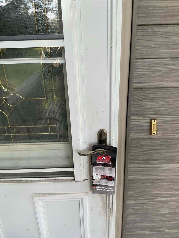 Responded to no-cooling call for attic-mounted air conditioning unit. Customer was not present upon arrival despite multiple attempts to make contact. Left door hanger with service information and contact details for customer to reschedule or discuss temporary repair options, as unit is scheduled for replacement with new installation.