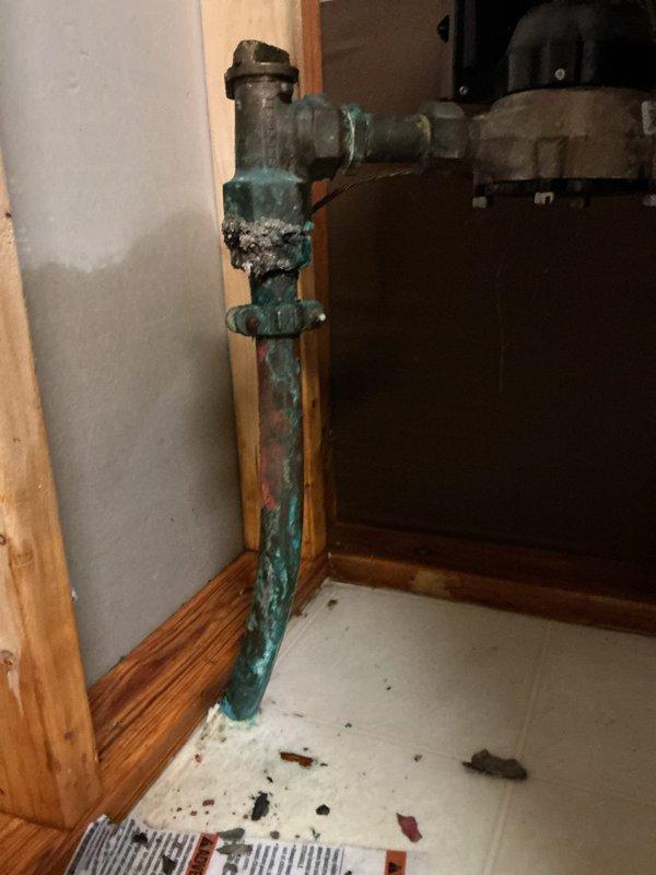 Responded to emergency basement flooding situation with arrival between 4-8. Upon investigation, identified source of leak as a pinhole failure in three-quarter inch copper 90-degree elbow fitting located immediately after the water meter. Main water line to house was shut off to prevent additional flooding and property damage. 

Assessed the affected plumbing system, which displayed significant age-related corrosion and verdigris patina on copper piping throughout the installation. The failed section exhibited compromised pipe integrity due to oxidation and deterioration. Removed the damaged three-quarter inch 90-degree fitting and surrounding compromised pipe section. Installed new copper pipe section with proper fittings to restore water supply line integrity. All connections were properly soldered and pressure-tested to ensure leak-free operation. Restored main water supply to residence and verified system functionality with no additional leaks detected.
