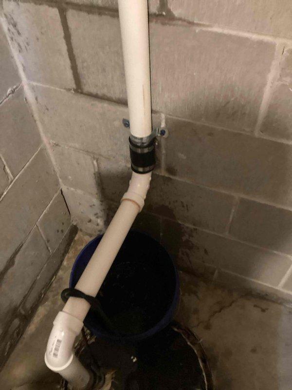 Responded to a sump pump drainage system leak in basement utility area. Upon inspection, identified active leak at 90-degree PVC fitting connection on vertical discharge pipe. Removed compromised drain section and 90-degree elbow fitting. Installed new PVC pipe section and fitting, securing connection with rubber coupling. Tested system for proper drainage flow and verified all connections were watertight with no further leakage.
