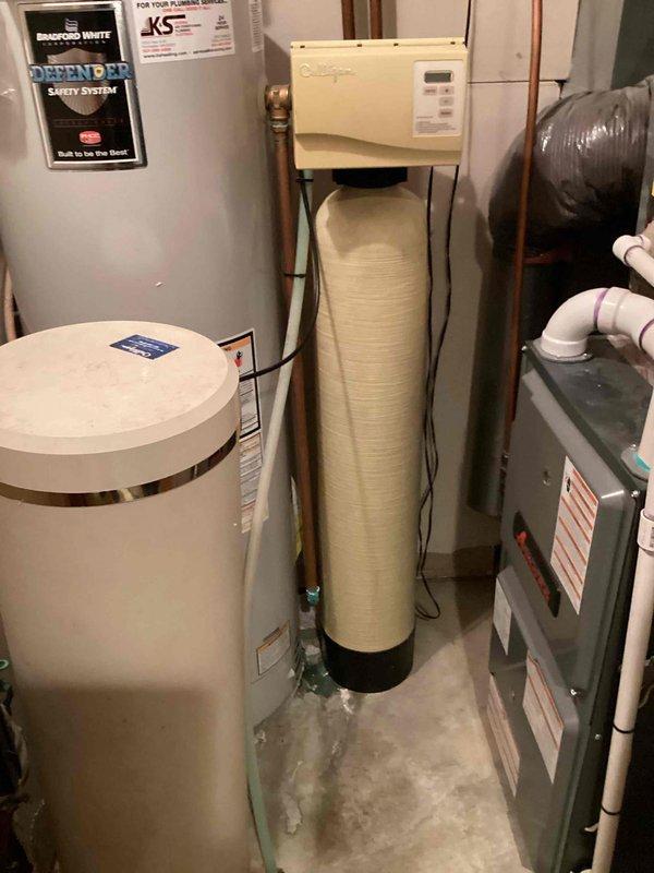 Responded to water heater leak concern and performed inspection of Bradford White tanked water heater system. Found minor discharge from temperature and pressure relief valve onto floor, which is normal operation when the valve activates to release excess temperature or pressure. Verified T&P valve functioning correctly as a safety component, opening and dripping until system parameters returned to safe levels. Confirmed water heater operating properly with no defects or required repairs.