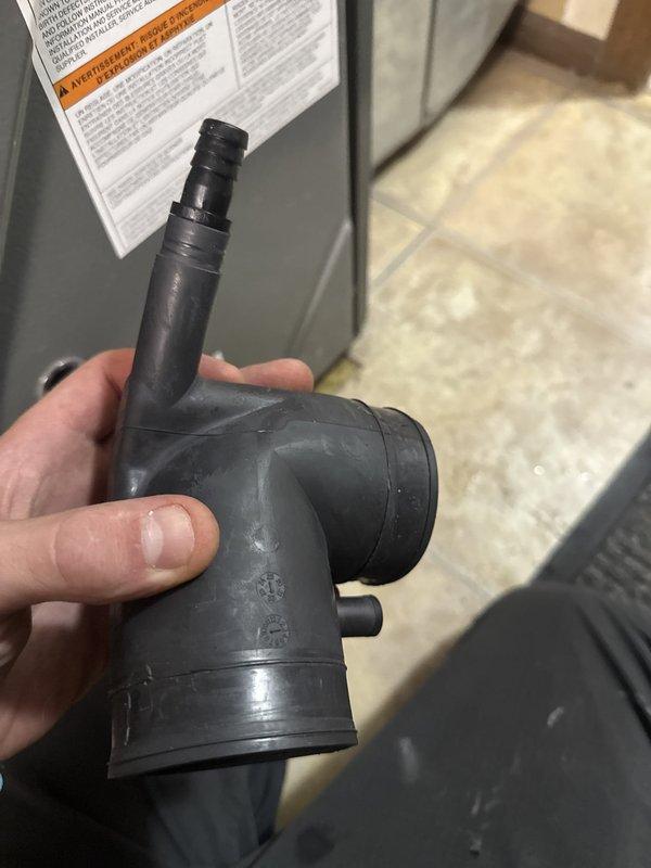 Responded to no-heat call with furnace leaking water and making gurgling noises. Found inducer assembly completely full of water caused by undersized 2" 90° elbow in condensate drainage system. Removed defective drain fitting and replaced with properly-sized component under Amana 10-year parts warranty. Verified proper drainage flow, tested inducer motor operation, and confirmed unit returned to normal heating operation.