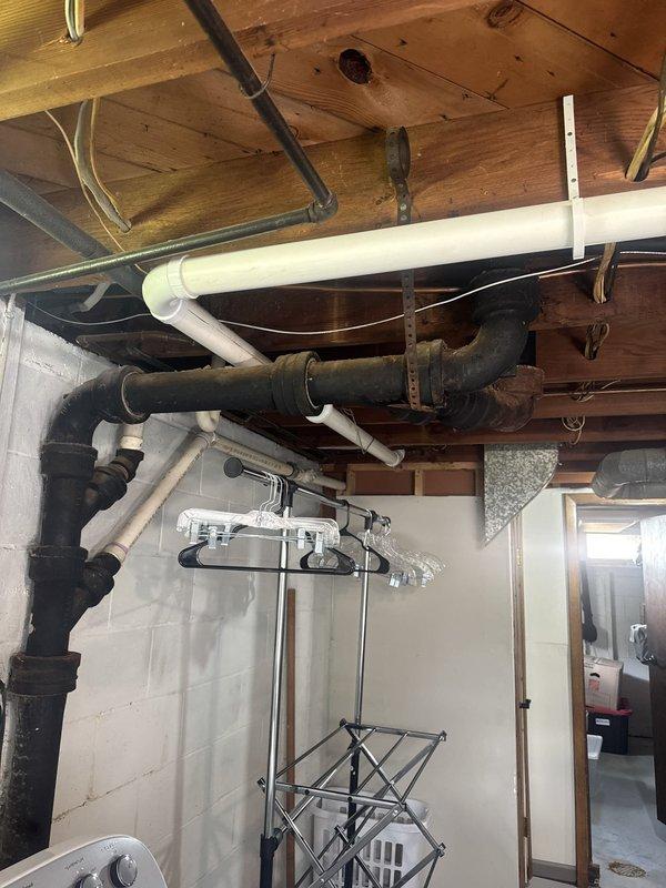 Responded to report of slow water leak in basement noticed by tenant after shower use. Conducted thorough inspection of exposed plumbing system including corroded cast iron pipes, white PVC drainage lines, and associated fixtures in utility area. Attempted to recreate leak conditions but unable to observe active water discharge or identify definitive source of reported moisture. Inspected ceiling-mounted piping, wall-mounted vertical runs, and connections near laundry appliances. No visible dripping, pooling, or wet areas detected during service visit. Documented existing plumbing conditions including significant rust and corrosion on older black iron piping system. Advised that leak may be intermittent or related to specific usage patterns. Possible callback may be required if leak reoccurs for further diagnostic evaluation.