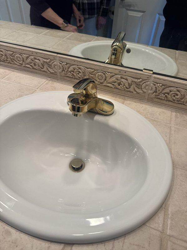 Responded to service call for multiple plumbing issues including leaking faucets in kitchen and bathroom areas. Performed assessment of bathroom fixtures, including bathtub/shower assembly with chrome single-handle faucet and tub spout showing signs of wear and discoloration, as well as dual-sink vanity equipped with gold-finished single-handle faucets. Completed faucet replacements in kitchen and bathroom to resolve leaking conditions. Also evaluated 24-year-old water heater exhibiting loud operational noises and recommended replacement due to age and performance issues.