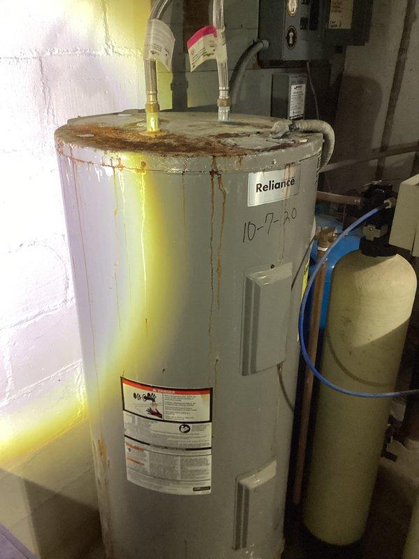 Responded to emergency service call for 50-gallon Reliance electric water heater experiencing sparking during operation. Upon inspection, found unit exhibited extensive corrosion with rust streaking throughout tank exterior and severely damaged electrical wiring connections at the heating elements. Due to compromised electrical components and advanced tank deterioration posing both safety and operational hazards, determined unit beyond repair and provided replacement estimate for new 50-gallon electric water heater installation.