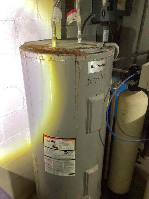Responded to emergency service call for 50-gallon Reliance electric water heater experiencing sparking during operation. Upon inspection, found unit exhibited extensive corrosion with rust streaking throughout tank exterior and severely damaged electrical wiring connections at the heating elements. Due to compromised electrical components and advanced tank deterioration posing both safety and operational hazards, determined unit beyond repair and provided replacement estimate for new 50-gallon electric water heater installation.
