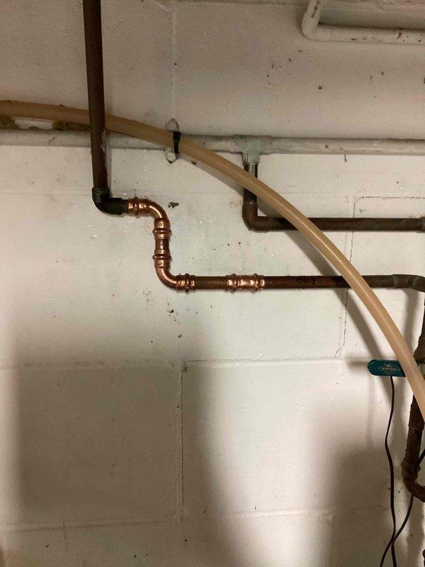 Responded to a pinhole leak on a 1/2" copper water line exiting the water softener. Located the compromised section of pipe, cut out the damaged portion, and installed new copper piping with proper fittings and joints. System was tested and restored to full operational status with no further leaks detected.