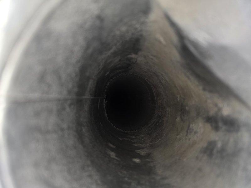 Completed comprehensive duct and dryer vent cleaning service to address significant dust and debris accumulation throughout the ventilation system. Pre-service inspection revealed heavy buildup of particulate matter coating the interior duct walls, with visible gray dust creating a matted, fibrous texture along the circular ductwork surfaces. Utilized professional duct cleaning equipment to thoroughly remove accumulated contaminants from the metallic corrugated ductwork, paying special attention to the ridges and valleys where debris had settled. Cleaned all accessible vents and registers, and performed complete dryer vent cleaning to restore proper airflow and reduce fire hazard risk. System now operating with improved air quality and ventilation efficiency.