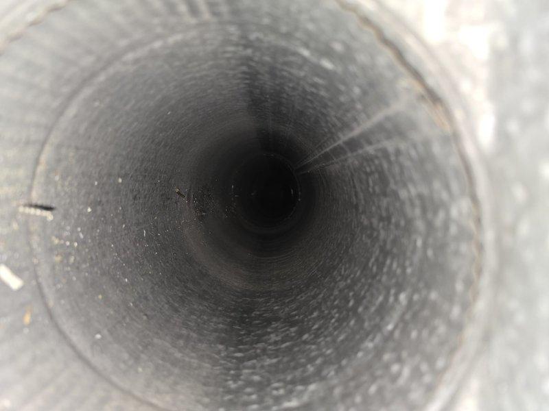 Completed comprehensive duct and dryer vent cleaning service to address significant dust and debris accumulation throughout the ventilation system. Pre-service inspection revealed heavy buildup of particulate matter coating the interior duct walls, with visible gray dust creating a matted, fibrous texture along the circular ductwork surfaces. Utilized professional duct cleaning equipment to thoroughly remove accumulated contaminants from the metallic corrugated ductwork, paying special attention to the ridges and valleys where debris had settled. Cleaned all accessible vents and registers, and performed complete dryer vent cleaning to restore proper airflow and reduce fire hazard risk. System now operating with improved air quality and ventilation efficiency.