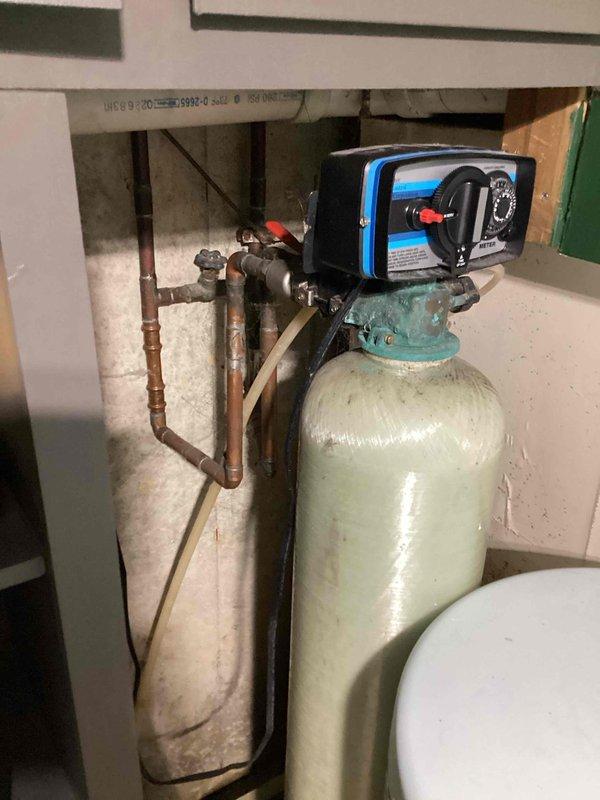 Responded to service call for water softener with incorrect settings. Upon arrival, inspected Superior brand water softener system installed in basement utility area with Bradford White water heater. Assessed control head, timer settings, and plumbing connections. Unable to adjust or reprogram Superior softener unit due to equipment limitations or compatibility issues. Documented existing installation with photographs showing system configuration, copper supply lines, and current operating conditions for future reference.