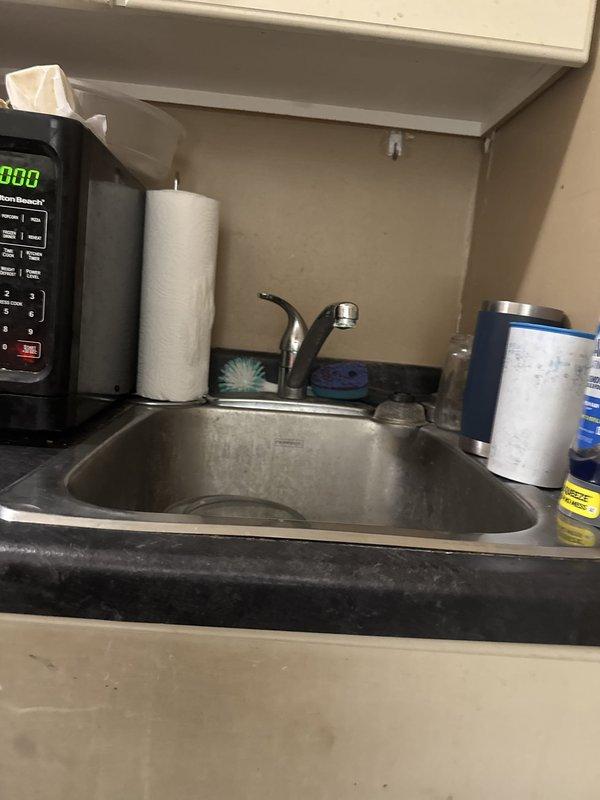Responded to building-wide low water pressure complaint. Investigated plumbing system and identified clogged cartridges in the main brass valve manifold assembly as the source of reduced flow throughout the facility. Removed and replaced affected cartridges, restoring proper water pressure to all fixtures. Verified system operation at kitchen sink and confirmed adequate pressure restoration.