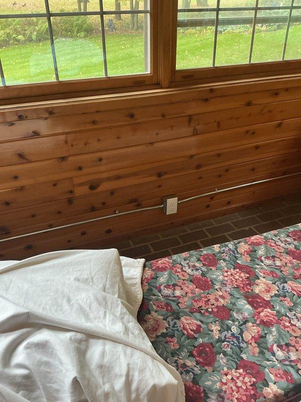 Completed electrical installation in four-season porch, including fishing wire from existing garage outlet to add new electrical outlets on wood-paneled walls. Successfully installed ceiling fan and additional light fixture, requiring tall ladder for overhead work. All fixtures and outlets tested and operational upon completion.