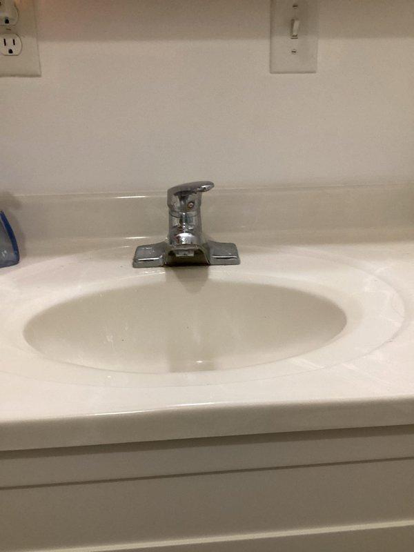 Responded to water leak under bathroom sink caused by cracked plastic component in the pop-up drain assembly. Removed existing lavatory faucet from basement bathroom and installed customer-provided chrome single-handle faucet with lever operation. Completed all supply line connections, installed pop-up drain assembly, and tested system under full water pressure. Verified proper operation of faucet handle, spout flow, and drain stopper mechanism with no leaks detected at supply connections or drain assembly.