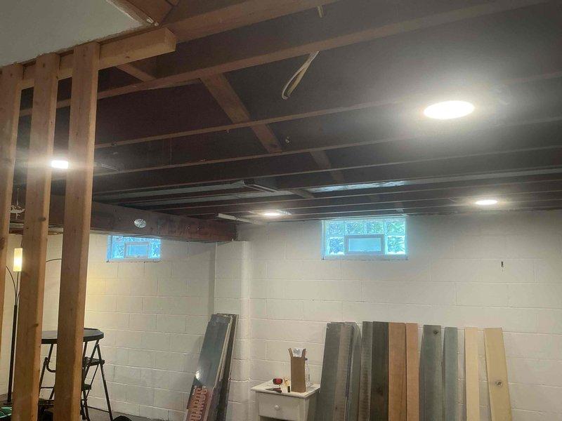 Installed seven recessed wafer lights in unfinished basement with exposed ceiling joists. Rerouted existing electrical wiring from under floor joists to run properly between joists to allow for future ceiling installation. Provided estimate for adding dedicated outlet under kitchen sink for garbage disposal.