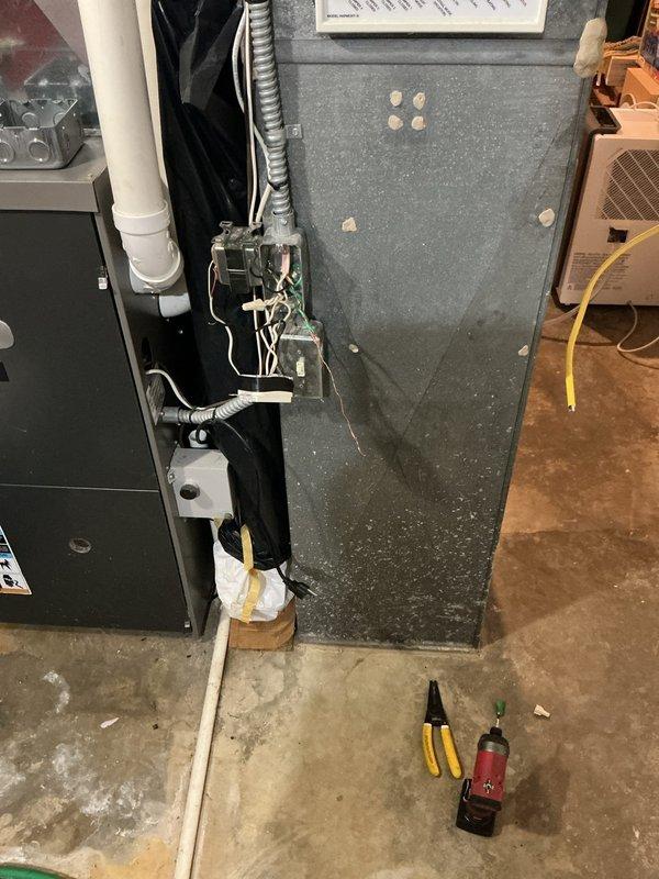 Completed installation of customer-provided generator transfer switch in residential basement utility area. Installed EZ switch with proper electrical connections to existing main service panel, ensuring code-compliant wiring and secure mounting to wooden wall structure. All circuit connections verified, panel labeled appropriately, and system tested for proper operation between utility and generator power sources.