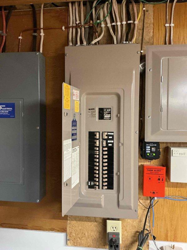 Completed installation of customer-provided generator transfer switch in residential basement utility area. Installed EZ switch with proper electrical connections to existing main service panel, ensuring code-compliant wiring and secure mounting to wooden wall structure. All circuit connections verified, panel labeled appropriately, and system tested for proper operation between utility and generator power sources.