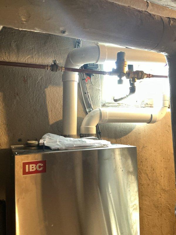 Responded to no hot water complaint and diagnosed low water pressure issue on IBC wall-mounted boiler system. Adjusted and increased system water pressure to restore proper operation of the hydronic heating unit. Verified hot water restoration and confirmed all valves, pressure gauges, and copper piping connections functioning correctly after pressure adjustment.