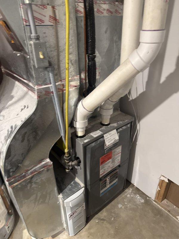 Responded to no heat call and discovered water accumulation in furnace blower assembly and inducer motor due to improperly installed condensate drain line. Found drain line routing error causing secondary drain pan to overflow and allowing carbon monoxide to leak through apartment drain system. Unit was immediately shut down and red-tagged for safety due to CO hazard and water damage to critical components. Provided estimate for corrective repairs including proper drain line installation and component assessment.