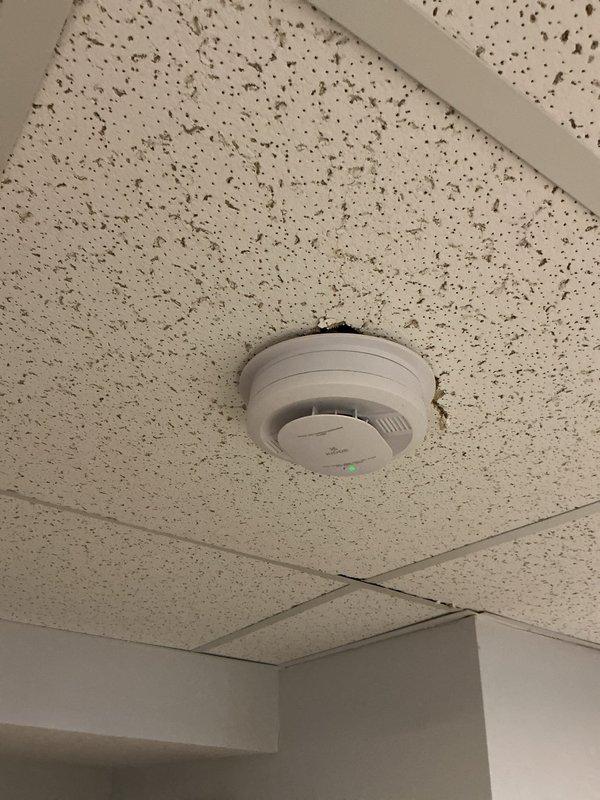 Performed inspection of hard-wired smoke alarm system and identified that one smoke detector was wired independently and not interconnected with the remaining detectors in the system. Confirmed operational status of individual units and documented ceiling-mounted smoke detector locations throughout the property.