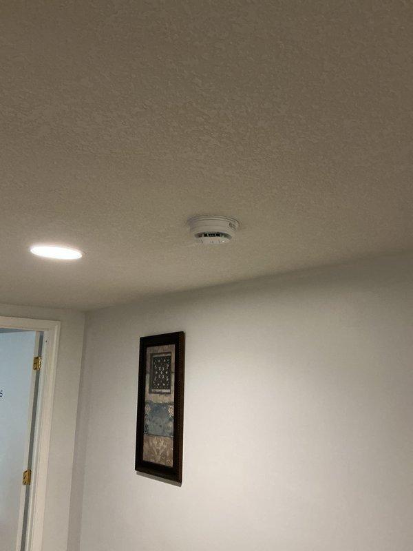 Performed inspection of hard-wired smoke alarm system and identified that one smoke detector was wired independently and not interconnected with the remaining detectors in the system. Confirmed operational status of individual units and documented ceiling-mounted smoke detector locations throughout the property.